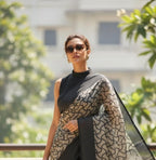 Woman wearing off-white and black printed saree with sunglasses, outdoor setting