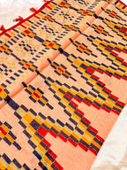 Peach ethnic fabric with geometric multicolor block patterns and red tassel border